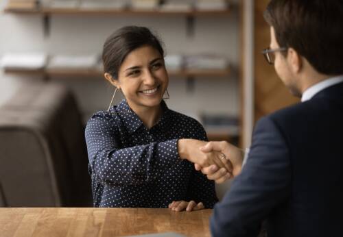 Woman and man shaking hands across a table